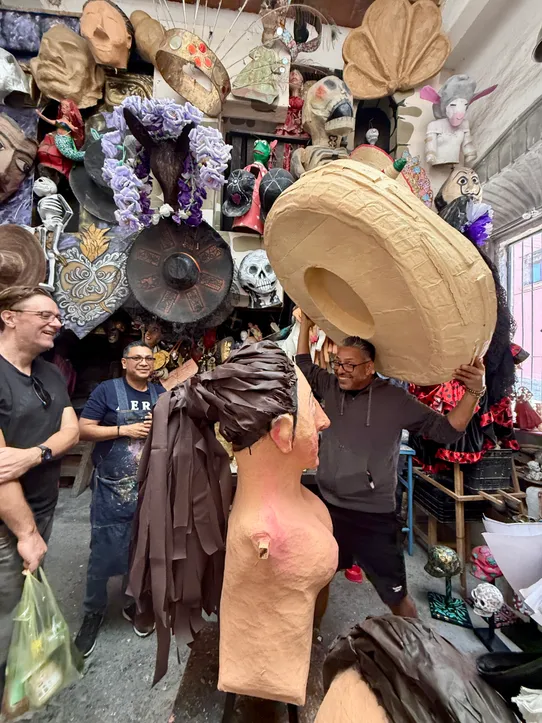 Hermes Arroyo showing a giant hat he is making