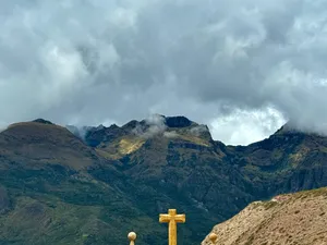 A stone cross against the cloud line