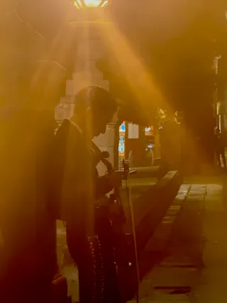 Mariachero beneath a street lamp