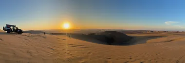 The dunes end to end, a buggy parked at the rim